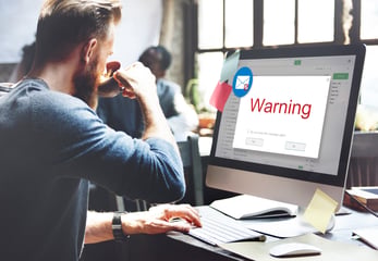 guy drinking coffee while receiving warning for online scam 