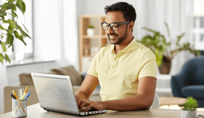 man with glasses working on laptop